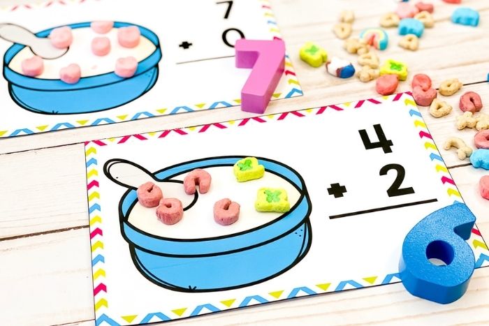 Using marshmallows to add, children are invited to place 4 colored marshmallows on the cereal and 2 of another color. Put it together to create the addition sentence 4+2=6.
